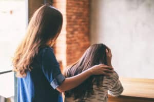 a person comforts another after seeing signs of drug and alcohol abuse