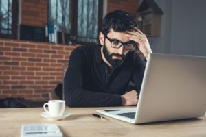 a person sits at a computer possibly researching Naloxone vs Naltrexone