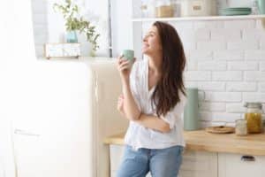 woman drinking coffee thinking of the reasons to get sober