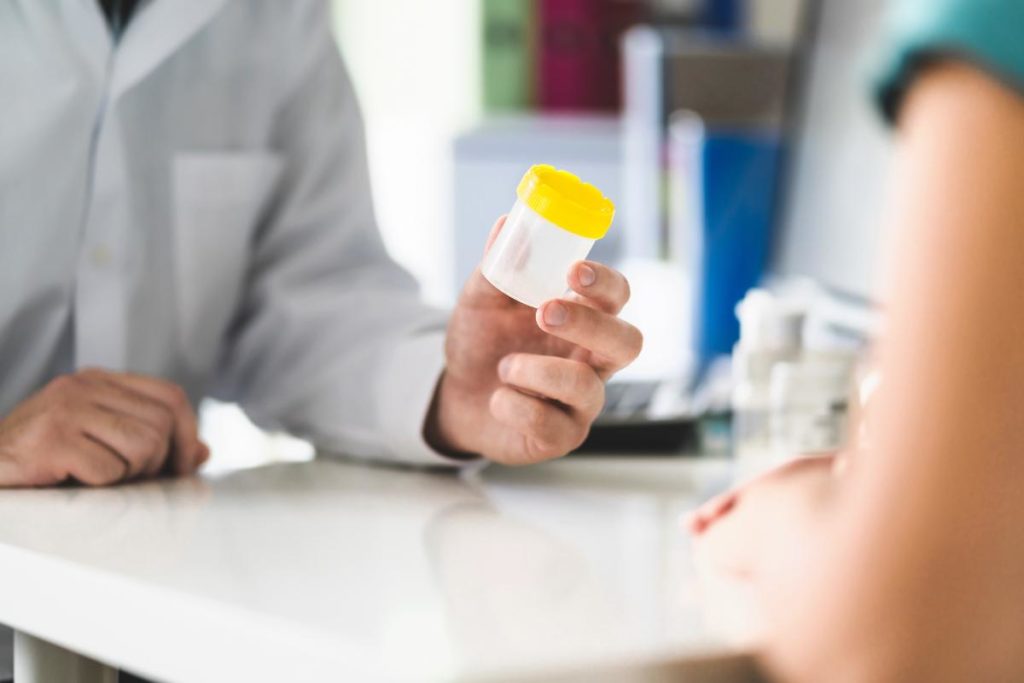 a person offers another person a urine sample cup to test for the most abused drugs