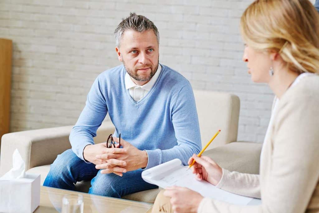 a person listens to a therapist during DMT Treatment and Rehab