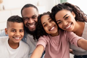 a family smiles after engaging in helpful family therapy techniques
