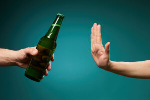 a person who has been through alcohol detox and treatment turns down a beer