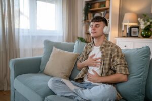 person listening to guided meditation on headphones as one of many tips on preventing relapse