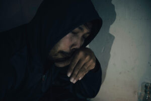person in hoodie sitting in the dark in need of tips to handle cocaine withdrawal