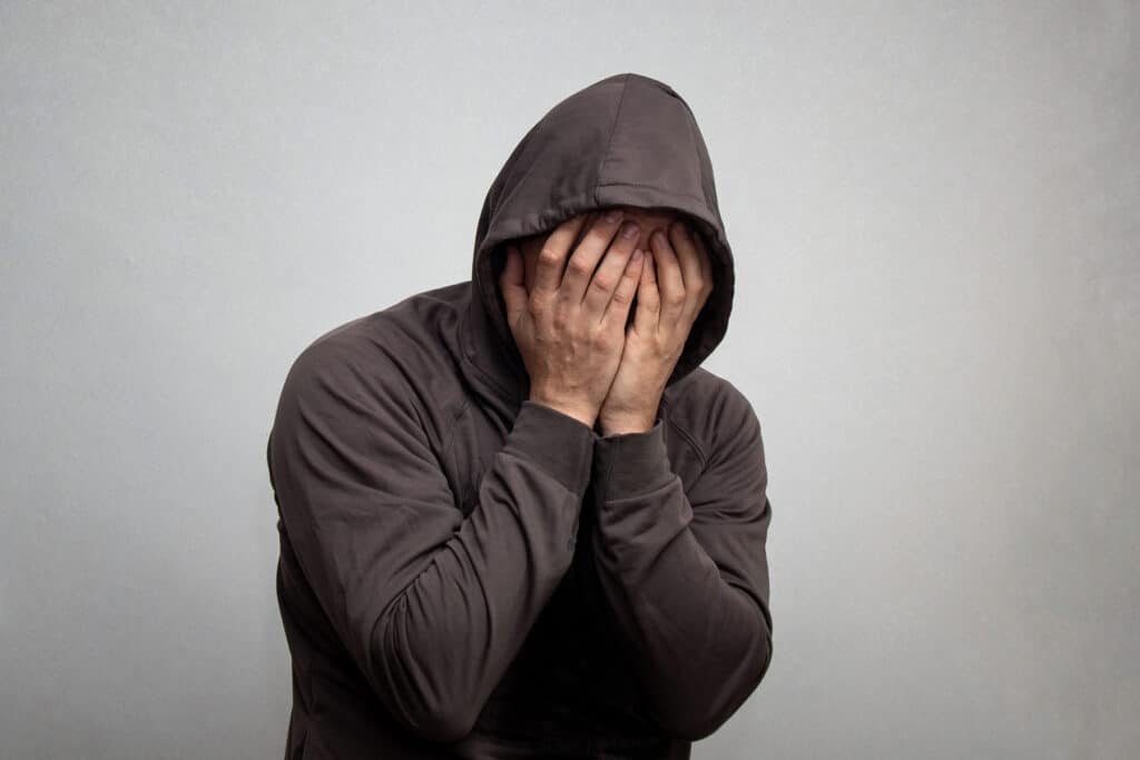 person in hoodie struggling with the dangers of fentanyl addiction